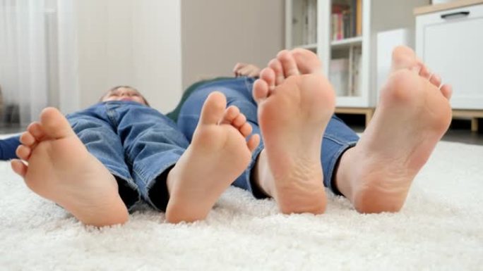 赤脚家庭躺在地毯上移动的特写滑稽镜头