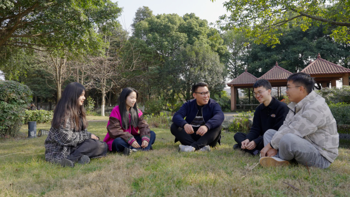 老师和学生在草坪坐着聊天