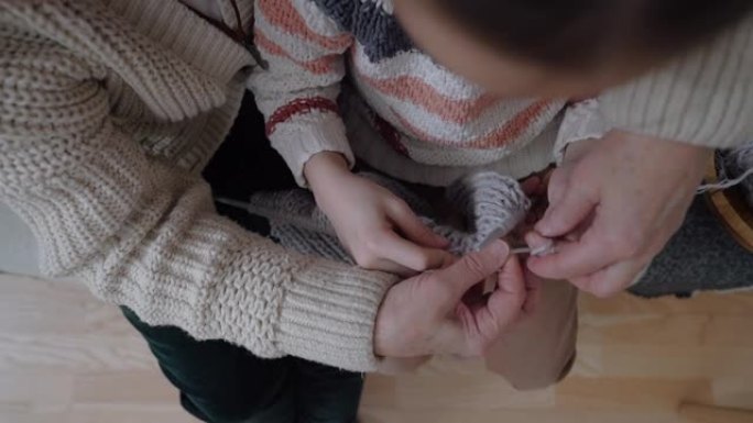 特写老年妇女教小女孩如何用辐条编织羊毛线