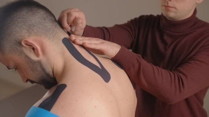 运动学家将胶带粘在患者的脖子上，运动员受伤后康复，骨软骨病的运动，4k 60p Prores HQ 