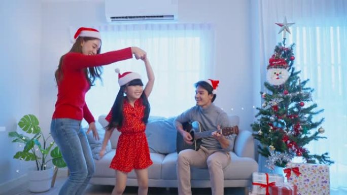亚洲可爱的家庭成员喜欢在家一起唱圣诞歌。年轻的小女儿感到高兴和兴奋，与家里的父母一起庆祝节日圣诞感恩