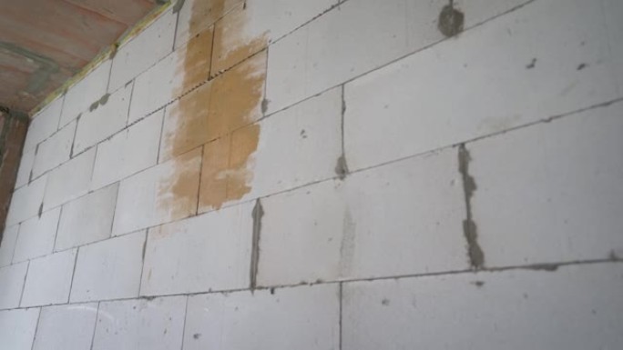 底漆倒在混凝土墙上。混凝土墙上涂底漆的工作油漆。在墙上涂橙色底漆