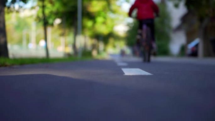 男孩在自行车道上踩自行车。自行车路线。自行车车轮的旋转。骑自行车。