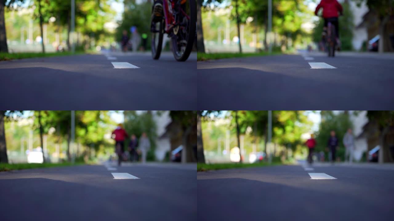 男孩在自行车道上踩自行车。自行车路线。自行车车轮的旋转。骑自行车。