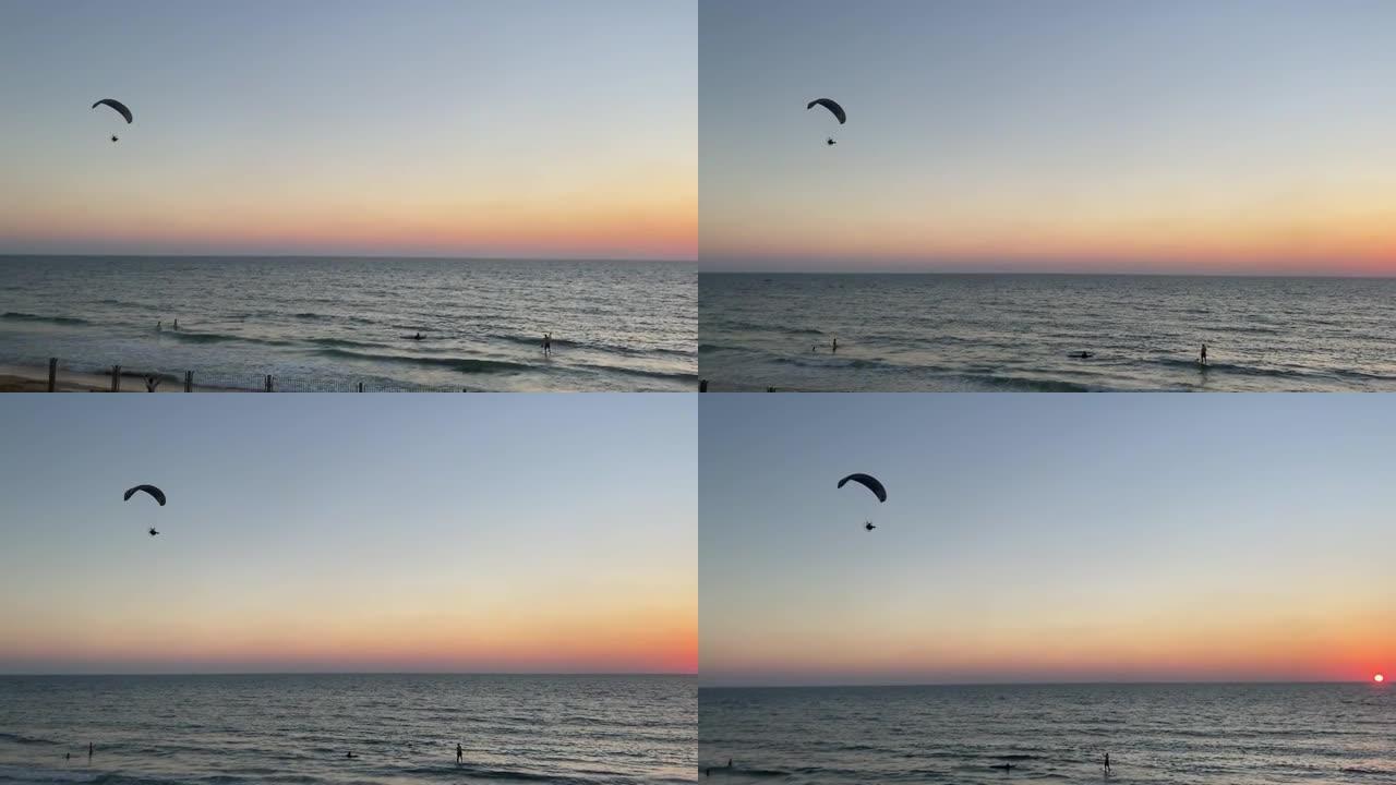 日落时海上的动力滑翔伞