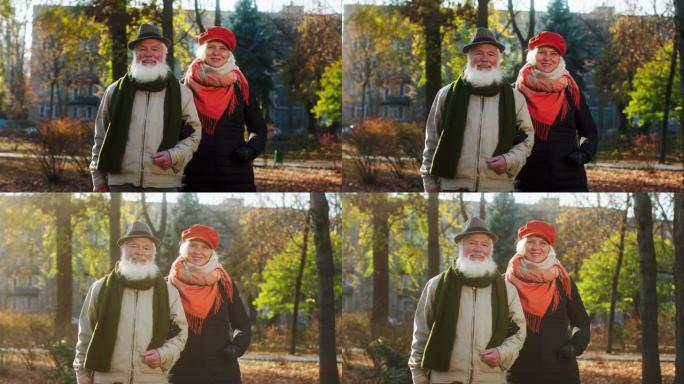 在寒冷的非盟里，在一个大公园里，非常随意和富有魅力的老夫妇在镜头前拥抱在一起，他们笔直地站着