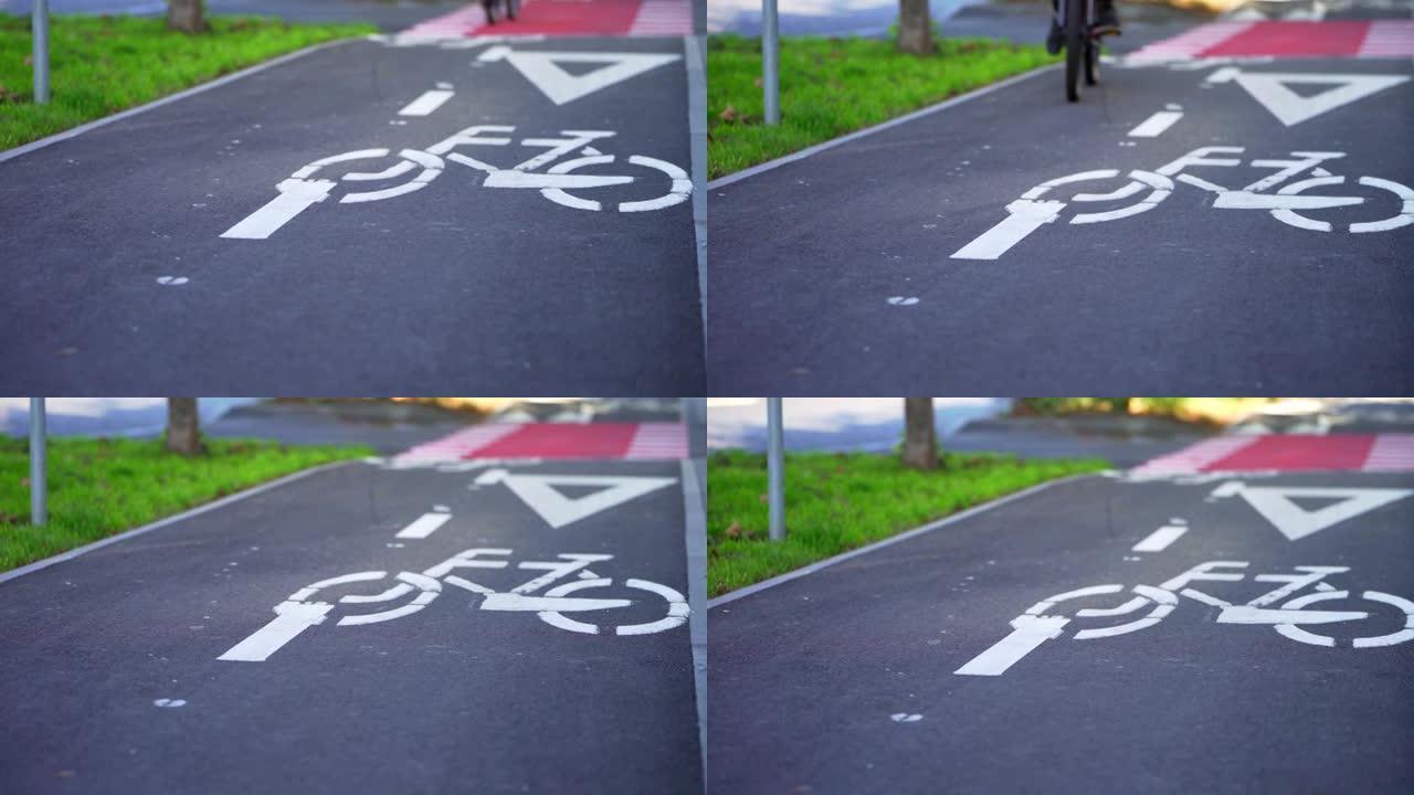 自行车车轮的旋转。骑自行车。自行车道上的自行车标志。男孩在自行车道上踩自行车