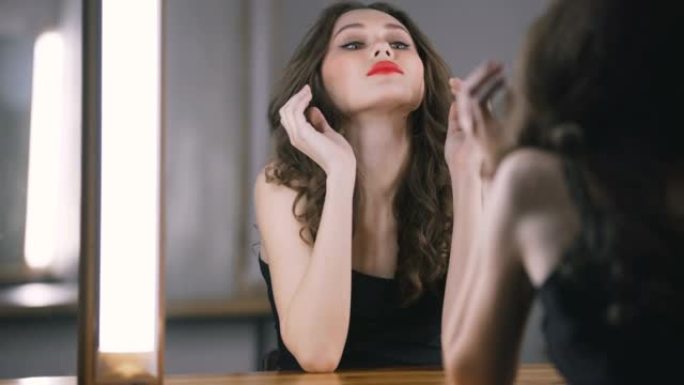 黑发女人在镜子附近使用智能手机擦拭嘴唇
