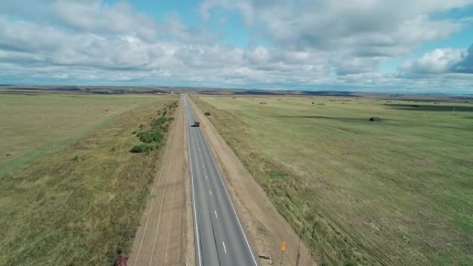 绿色田野与蓝天之间的城际道路的鸟瞰图。美丽的早晨风景。