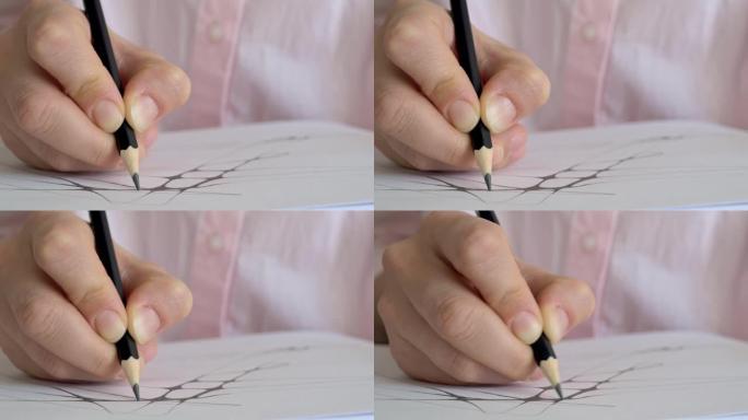 用手指拿着黑色铅笔在纸上画线的特写手为未来的创作艺术和绘画准备素描