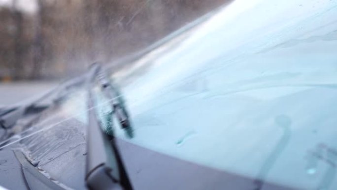 带有工作挡风玻璃雨刷的汽车挡风玻璃的侧视图。