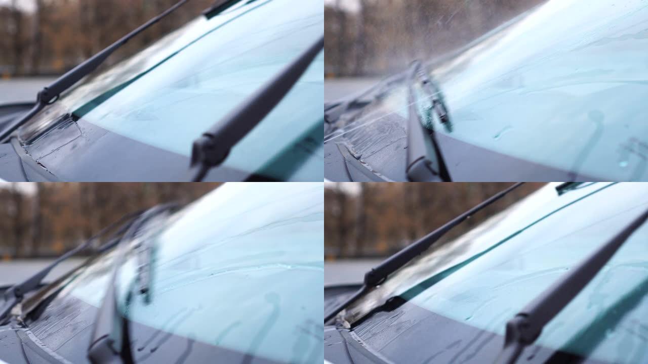 带有工作挡风玻璃雨刷的汽车挡风玻璃的侧视图。