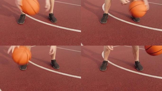 腿部男子通过在室外球场上两腿之间滚动篮球来练习球技