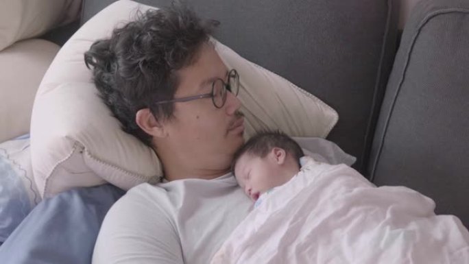 4k快乐疲惫的亚洲父子早上睡在沙发上。