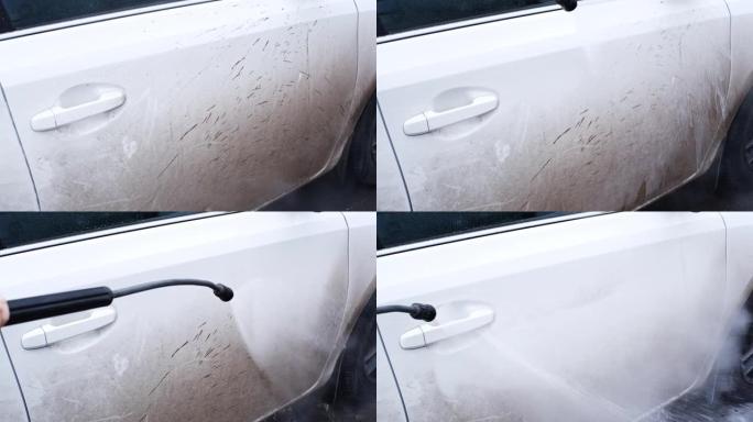 自助洗车店的白人妇女使用带有温水和底盘洗发水的高压清洗机洗掉白色车辆上的污垢和泥土，产生活性泡沫的雾