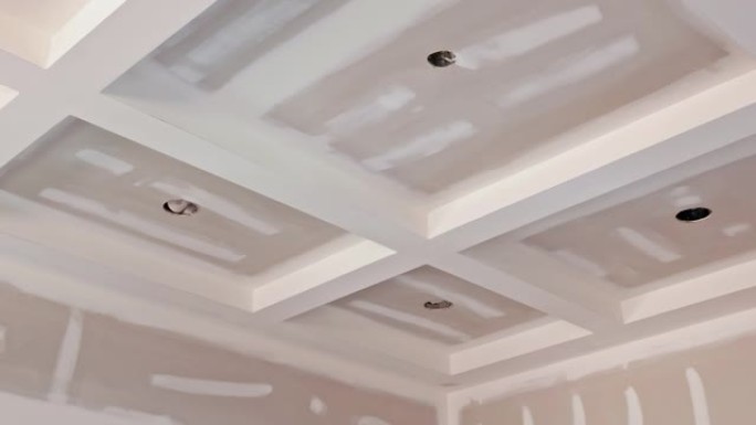 在墙壁和天花板上铺设抹灰石膏，以准备油漆的干墙接缝
