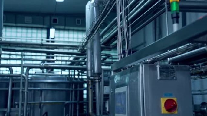 牛奶工业厂房内部。用于生产乳制品的带有金属管的新设备。现代化的牛奶工厂，配备自动化设备。