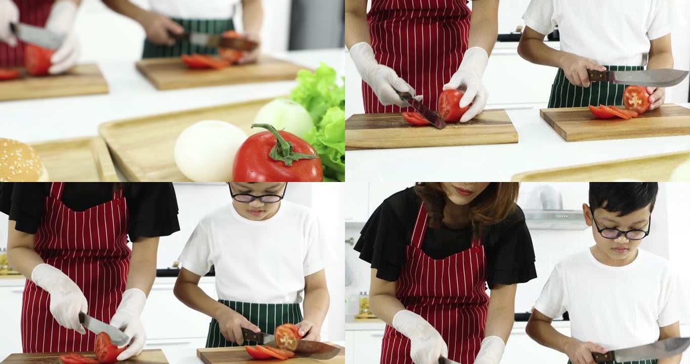 可爱的母亲教年轻的小儿子如何在现代白色调厨房切西红柿做汉堡。家庭中爱与关系的概念。