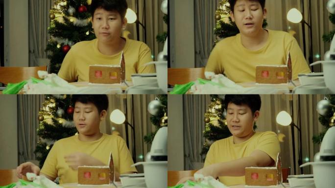 亚洲男孩晚上在家和姐姐一起做姜饼屋，圣诞节庆祝生活方式。
