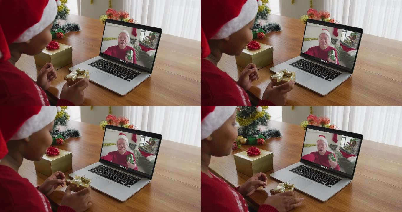 戴着圣诞老人帽子的非洲裔美国妇女使用笔记本电脑进行圣诞节视频通话，屏幕上有男人