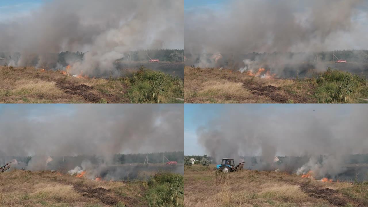 夏天在村庄附近的田野里烧干草，拖拉机扑灭了大火