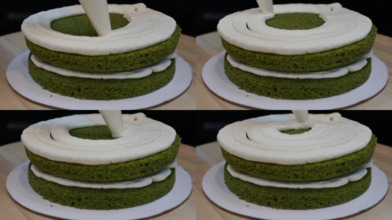 在菠菜海绵绿色蛋糕上涂一层厚厚的奶油