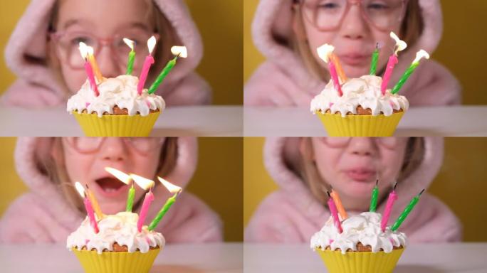 穿着粉色工作服的快乐小女孩在派对上吹出五支生日蛋糕上的蜡烛。特写女孩的脸。慢动作生日快乐视频横幅