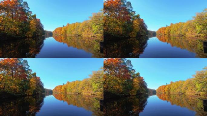 平静的湖泊，岸边有秋天的彩色树木，映在微动的水中