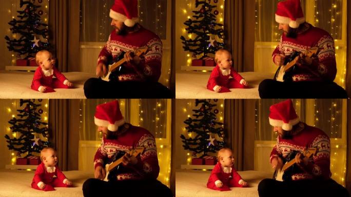 父亲戴着圣诞老人的帽子和毛衣给他的小孩弹吉他。宝贝看着他，听着，微笑着。圣诞灯背景。圣诞节快乐家庭概