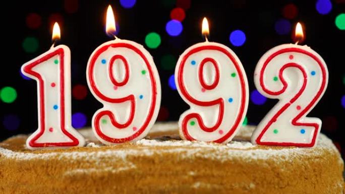 生日蛋糕与白色燃烧的蜡烛在数字1992的形式