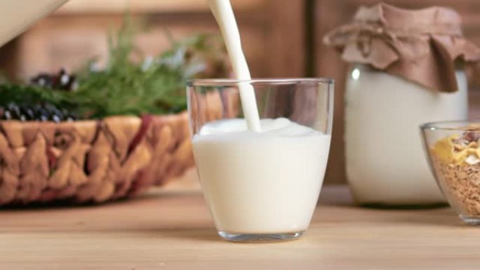 男性手将牛奶加入玻璃杯中，以保持健康的慢动作。倒农场乳制品