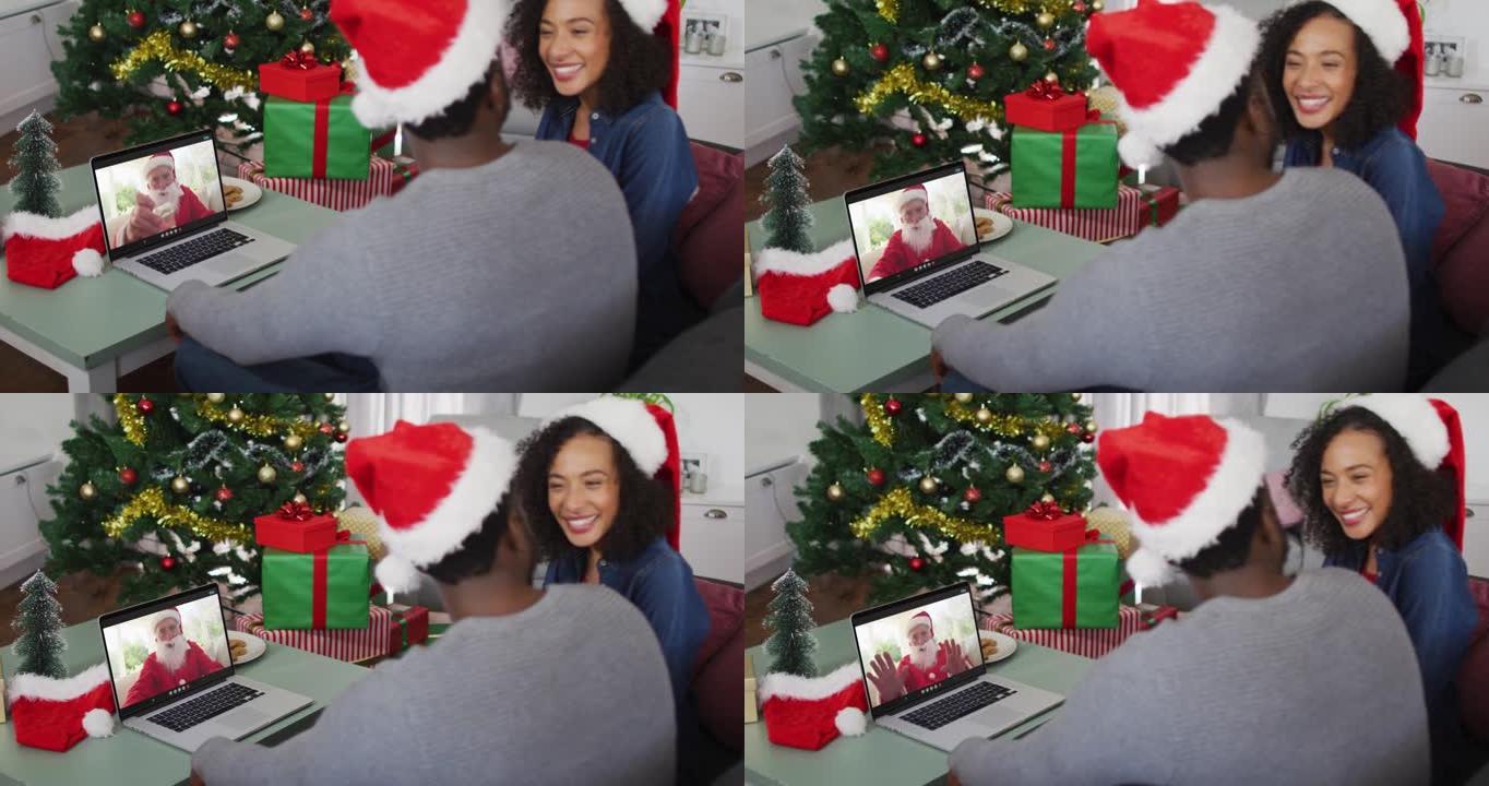 圣诞节时，与圣诞老人一起在笔记本电脑上视频通话的快乐非洲裔美国夫妇