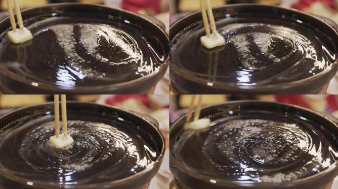 正面视图，用筷子把黄油涂在锅上。