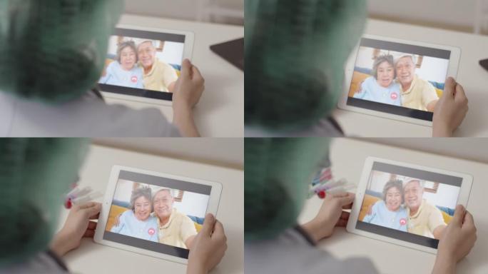 亚洲医生在新型冠状病毒肺炎大流行期间在医院工作时使用平板电脑视频通话给父亲和母亲。