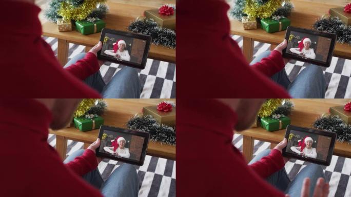白人男子挥舞并使用平板电脑进行圣诞视频通话，屏幕上有微笑的女人