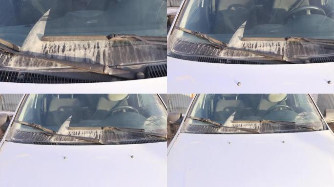 汽车雨刷在肮脏的挡风玻璃上，汽车的外观