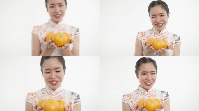 中国妇女在农历新年时拿着橘子代表好运，财富和吉祥。