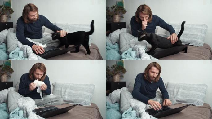 生病的男人咳嗽，在床上用电脑工作，猫四处走动