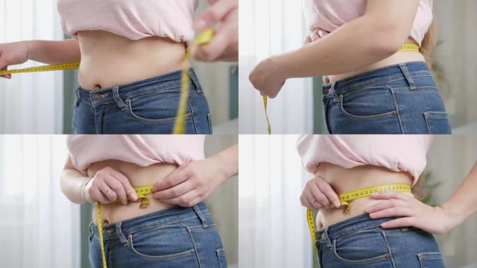 穿着牛仔裤的年轻女子用卷尺测量她苗条的平腰。节食、减肥和健康的生活方式的概念。