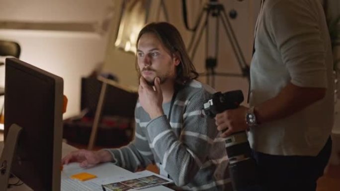 摄影师向报纸办公室的报纸编辑展示材料