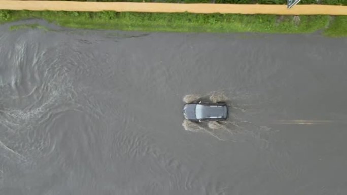 大雨过后，汽车在洪水泛滥的街道上行驶的城市交通鸟瞰图。道路排水系统存在的问题