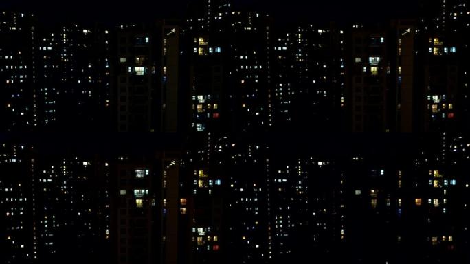 深夜，多层公寓楼窗户上的光线流逝。大城市的生活。光之小夜曲
