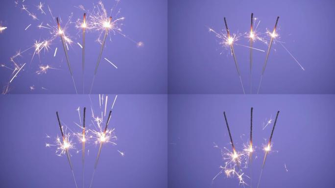 在紫色或紫色背景上关闭明亮燃烧的三个火花的横幅。圣诞快乐或新年快乐的概念。4k分辨率视频