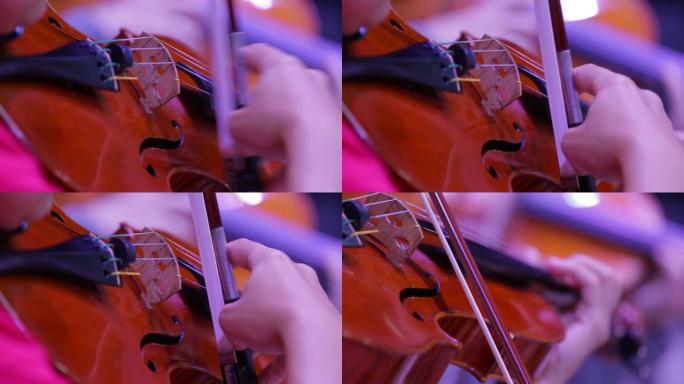 小提琴和带弓的手的特写镜头。交响乐团。小提琴家的表演。古典音乐