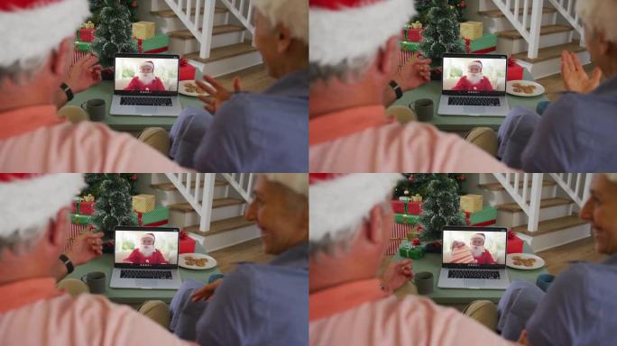 快乐的高级高加索夫妇在圣诞节与圣诞老人在笔记本电脑上进行视频通话