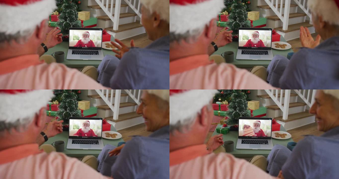快乐的高级高加索夫妇在圣诞节与圣诞老人在笔记本电脑上进行视频通话