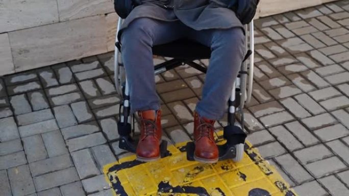 瓷砖街道地板和坐轮椅的男子上的残疾黄色标志
