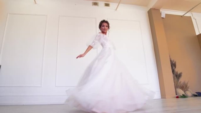 一位穿着白色连衣裙的美丽新娘为摄影师站着摆姿势，旋转。