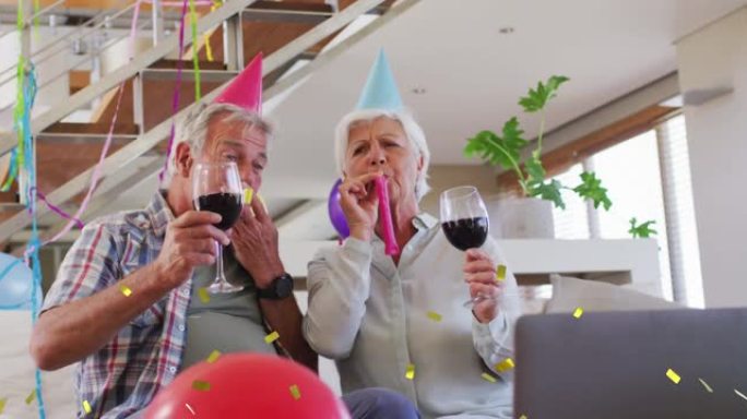 快乐的高加索高级夫妇戴着派对帽制作生日笔记本电脑视频通话喝酒