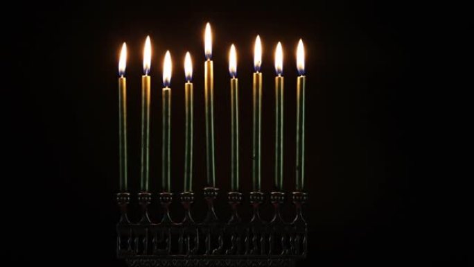 在黑暗中关闭光明节用蜡烛燃烧的烛台。